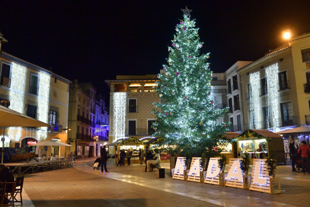 Plaça de l'Ajuntament d'Igualada de nit durant la Fira de Nadal amb l'arbre de Nadal il·luminat